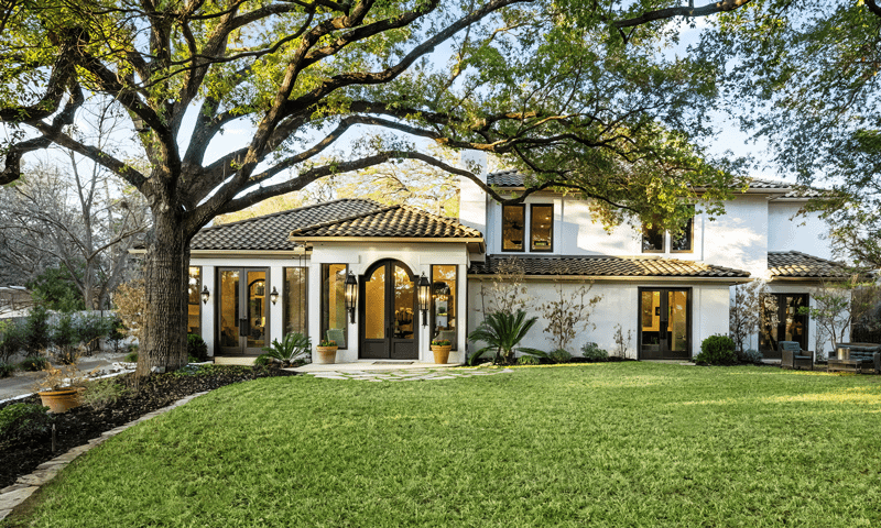 Home with large tree trimmed in Kirby, TX
