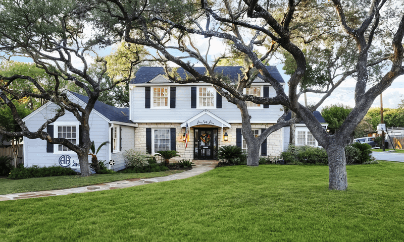 Artfully pruned trees providing an inviting entrance to a residential home in Terrell Hills, TX, serviced by Viva Trees