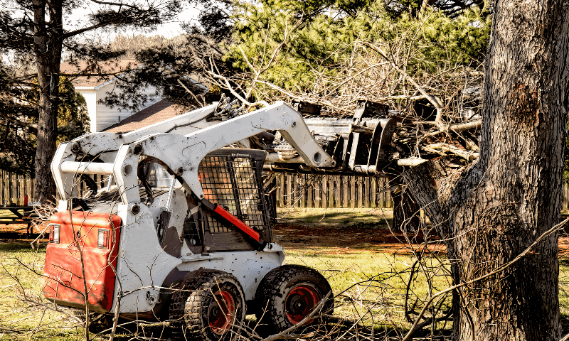 Skid loader being used to clear away debris